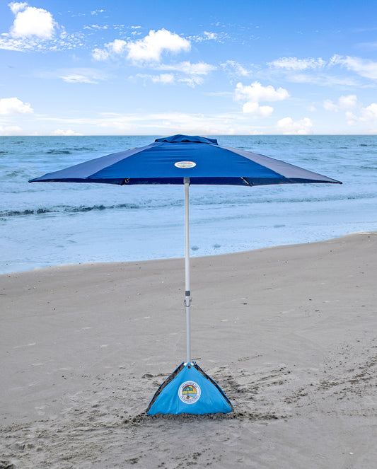 woman reading a book under a windproof beach umbrella