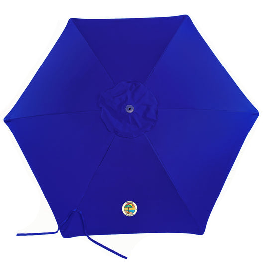 woman setting up wind resistant beach umbrella on beach